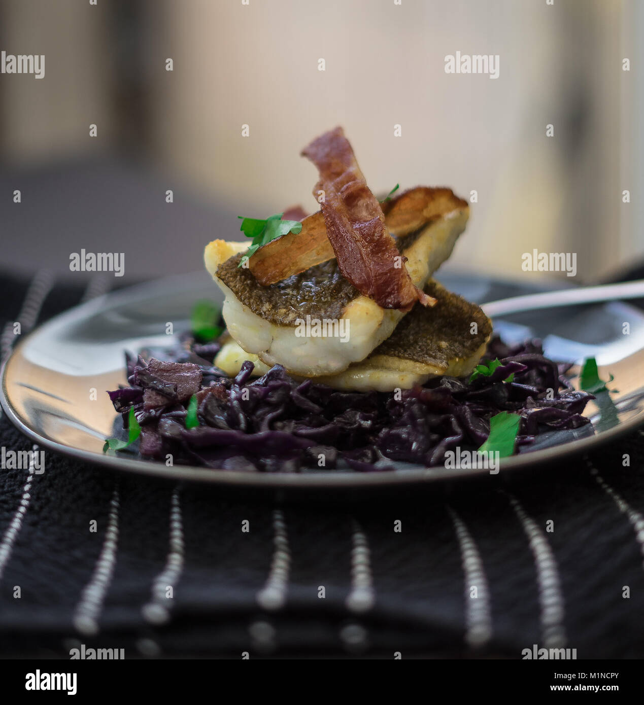 Gebratene Brill auf einem Bett von geschmorten Rotkohl und mit durchwachsener Speck serviert. Stockfoto