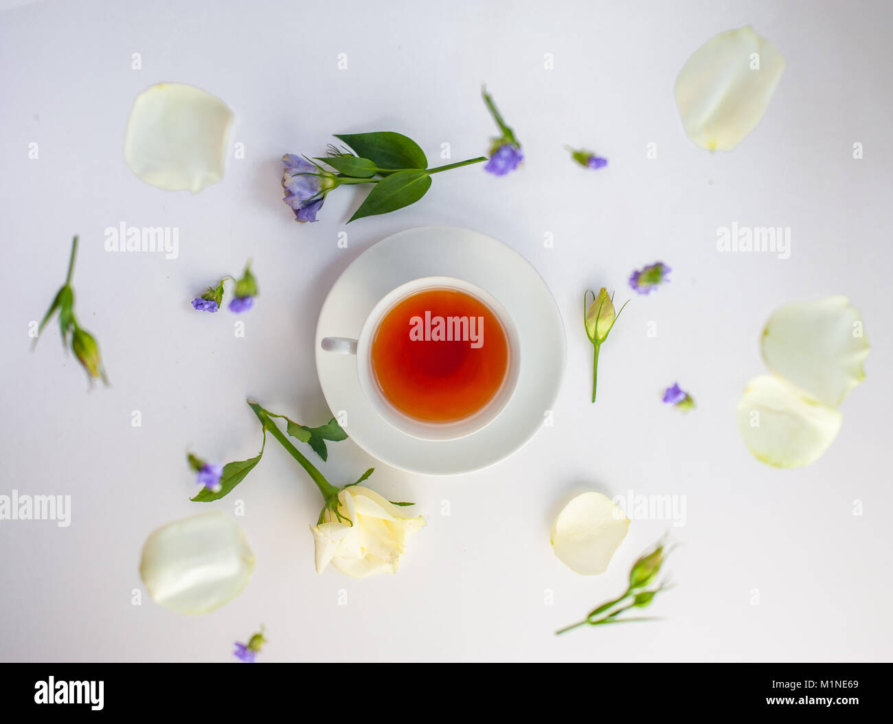 Flatlay mit eleganten Teeservice surrounde von Blumen Stockfoto