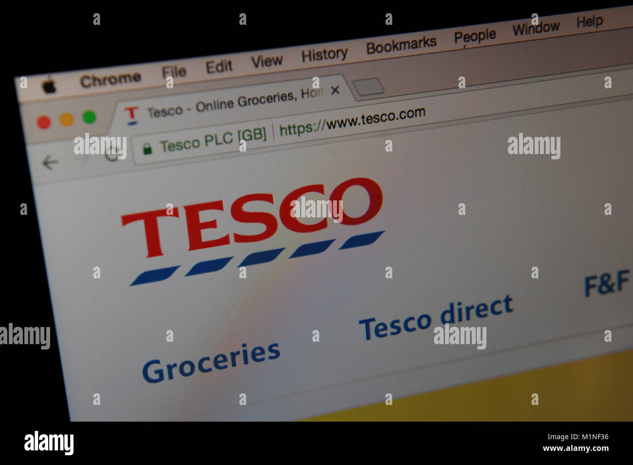 Der Supermarkt Tesco website ist durch ein Vergrößerungsglas gesehen Stockfoto