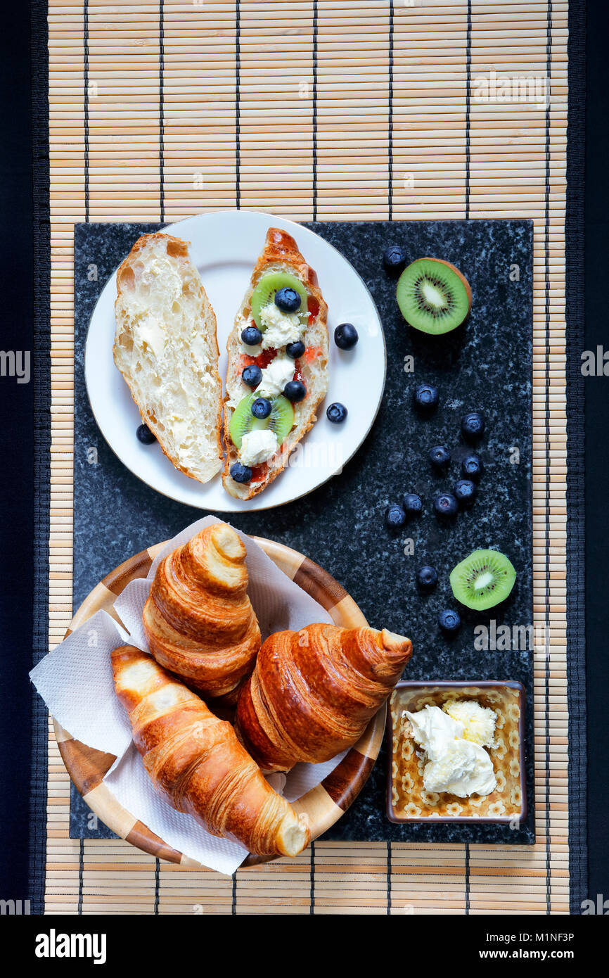 Frisch gebackene Croissants mit frischer Sahne, Kiwi und Blaubeeren Stockfoto