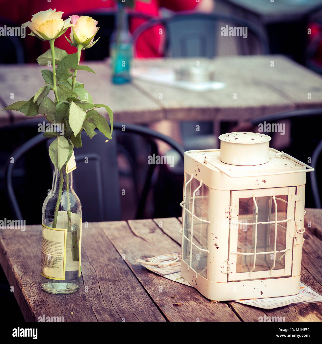 Zwei Rosen und einem Kerzenhalter auf einem pub Holztisch, Amsterdam, Holland Stockfoto