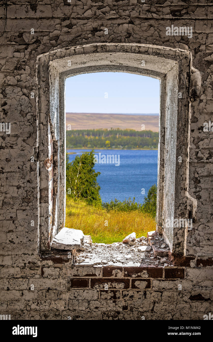 Ein Blick aus dem Fenster Loch eines alten heruntergekommenen verlassenen Hauses. Stockfoto