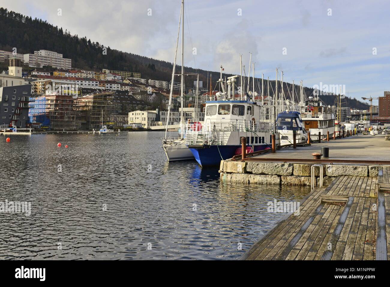 Boatbridge mit Booten und Wohngebäude am Ufer der Bucht Solheimsviken in der norwegischen Stadt Bergen, 1 März 2017 | Verwendung weltweit Stockfoto