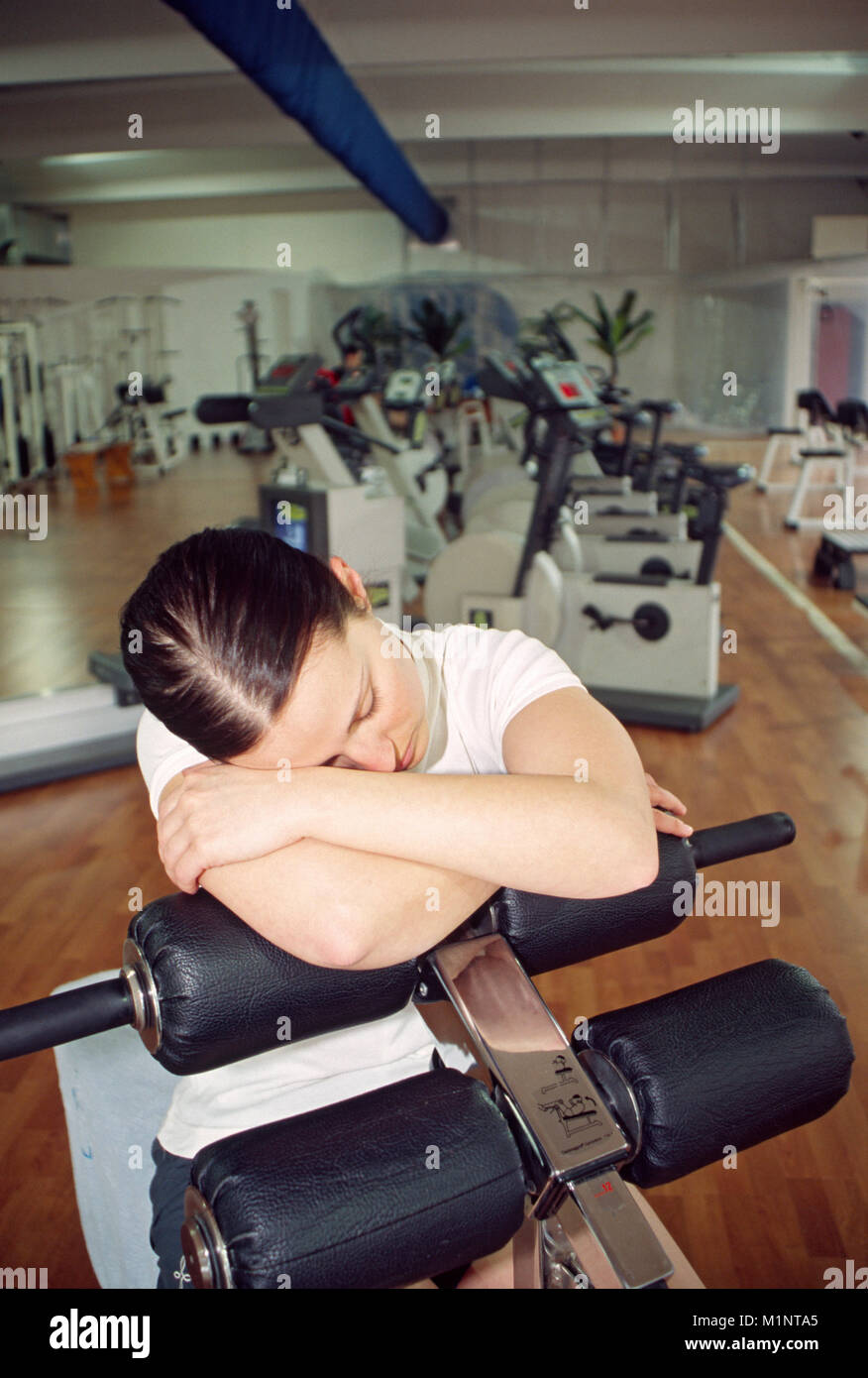 Junge Frau Schlafen in der Turnhalle Stockfoto