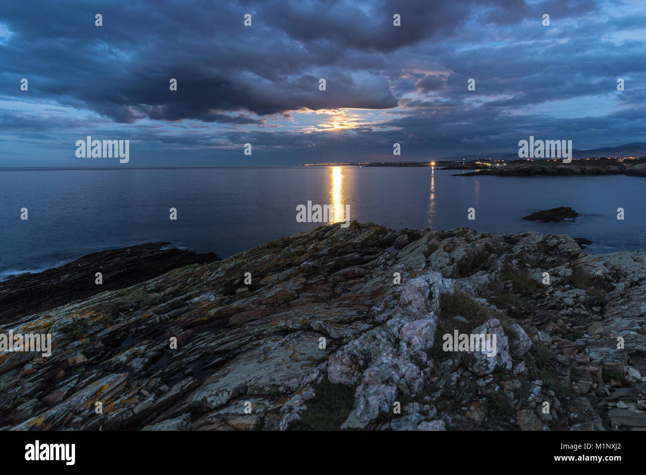 Vollmond an die Küsten Galiciens versteckt unter den mannigfaltigen Wolken des Himmels, von Zeit zu Zeit guckte auf dem Meer spiegeln Stockfoto