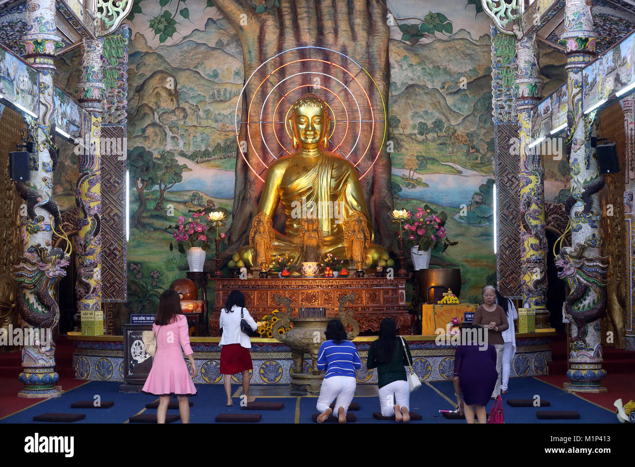 Sitzung Golden Buddha Figur in der Haupthalle und Anbeter beten zum Buddha, Linh Phuoc Pagode, Dalat, Vietnam, Indochina, Südostasien, Asien Stockfoto