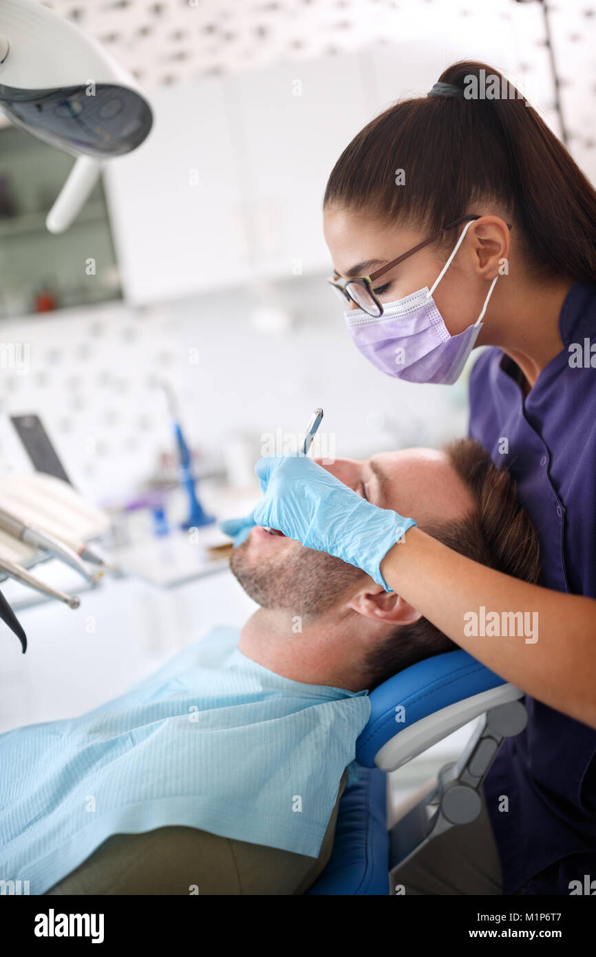 Weiblichen Zahnarzt bei der Arbeit mit den Patienten in der Zahnarztpraxis Stockfoto