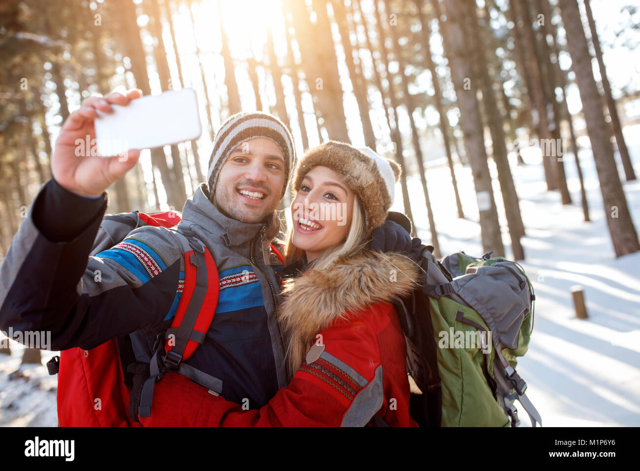 Junge Frau und Mann in Liebe und Foto zusammen im Winter Stockfoto