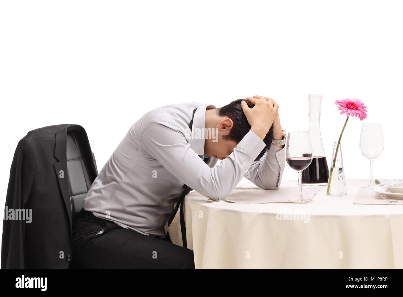 Verzweifelten Mann allein sitzen an einem Tisch im Restaurant mit seinem Kopf nach unten isoliert auf weißem Hintergrund Stockfoto
