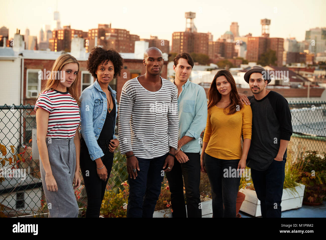 Sechs Freunde, die zusammen auf einem Brooklyn auf dem Dach Stockfoto