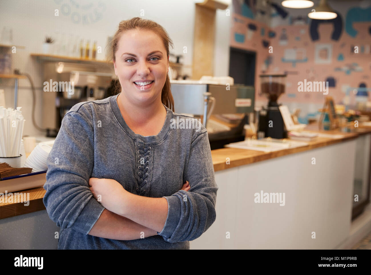 Junge Frau lächelnd in die Kamera an der Theke in einer Bäckerei Stockfoto