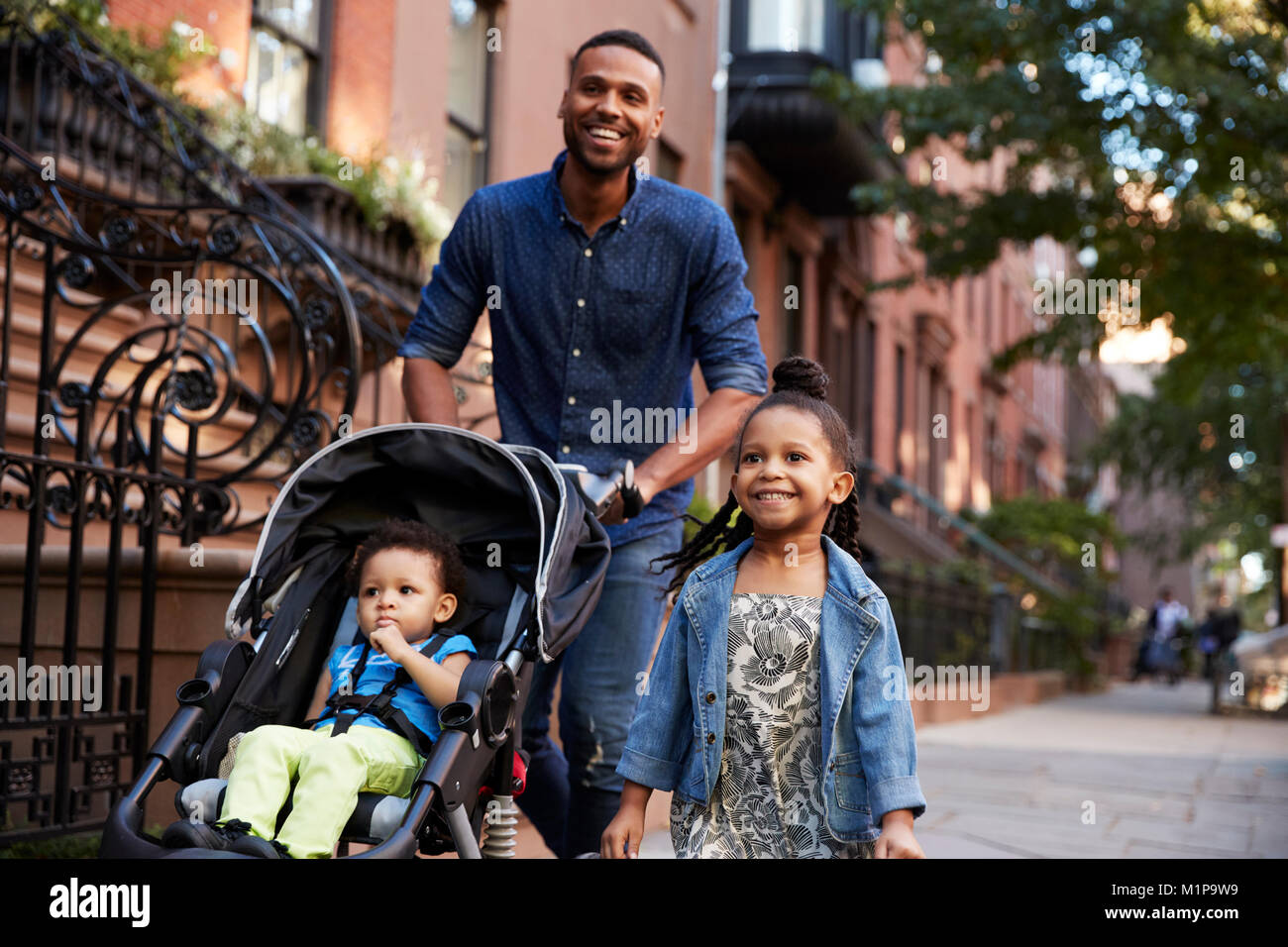 Vater und zwei Töchter bei einem Spaziergang auf der Straße, in der Nähe Stockfoto