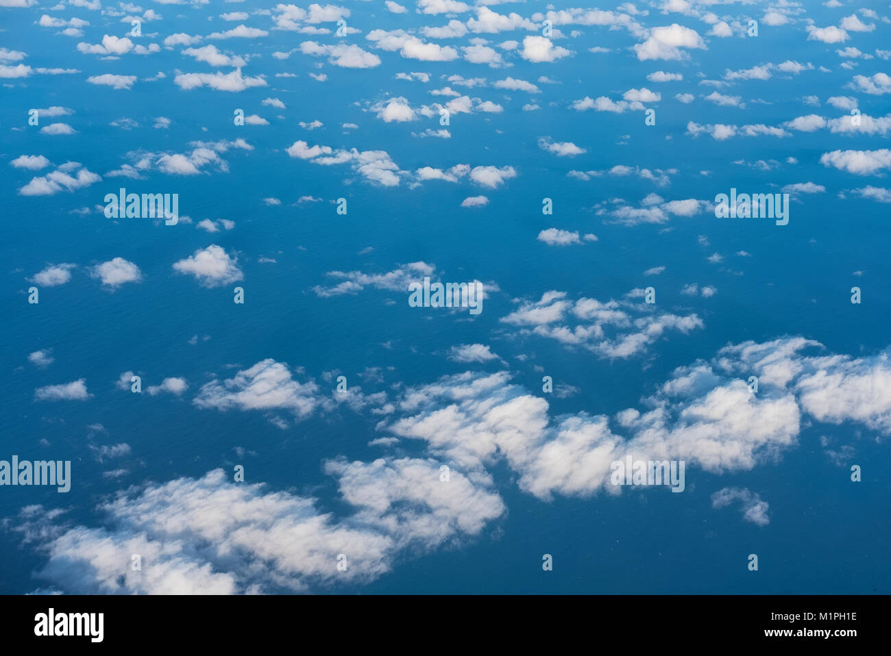 Mit Blick auf das blaue Meer mit weißen Wolken verstreut Stockfoto