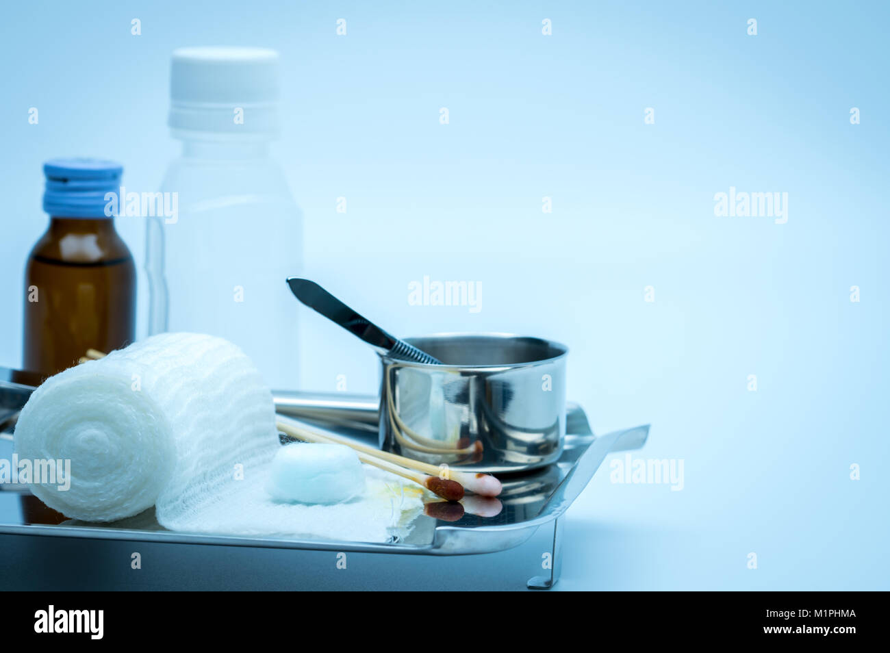 Wundversorgung Abrichten auf Platte aus rostfreiem Stahl. Tupfer mit Alkohol, Wattestäbchen mit Povidon Jod, Pinzette und Bandage entsprechen. Stockfoto