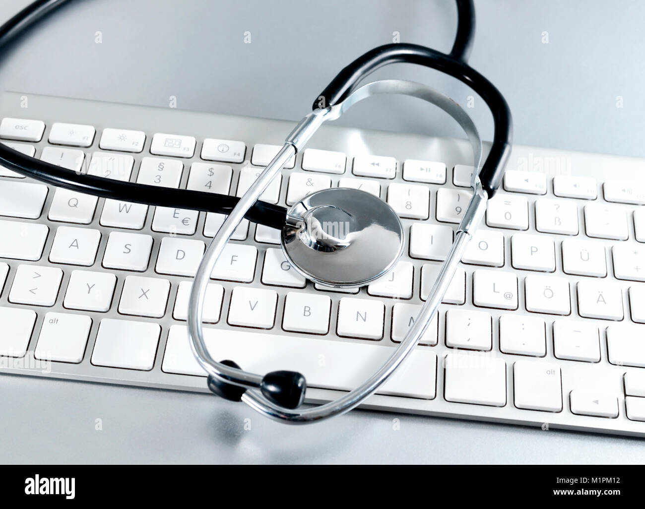 It-support Thema mit Stethoskop und PC-Tastatur. Tastenfeld und medizinische Ausrüstung, Virus reparieren oder medizinische Untersuchung. Stockfoto