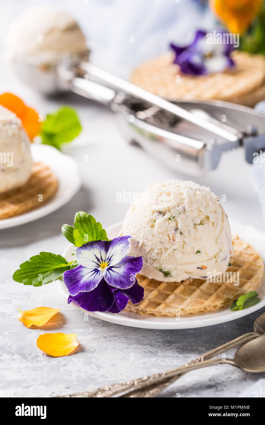 Vanilleeis mit essbaren Blüten Stockfoto