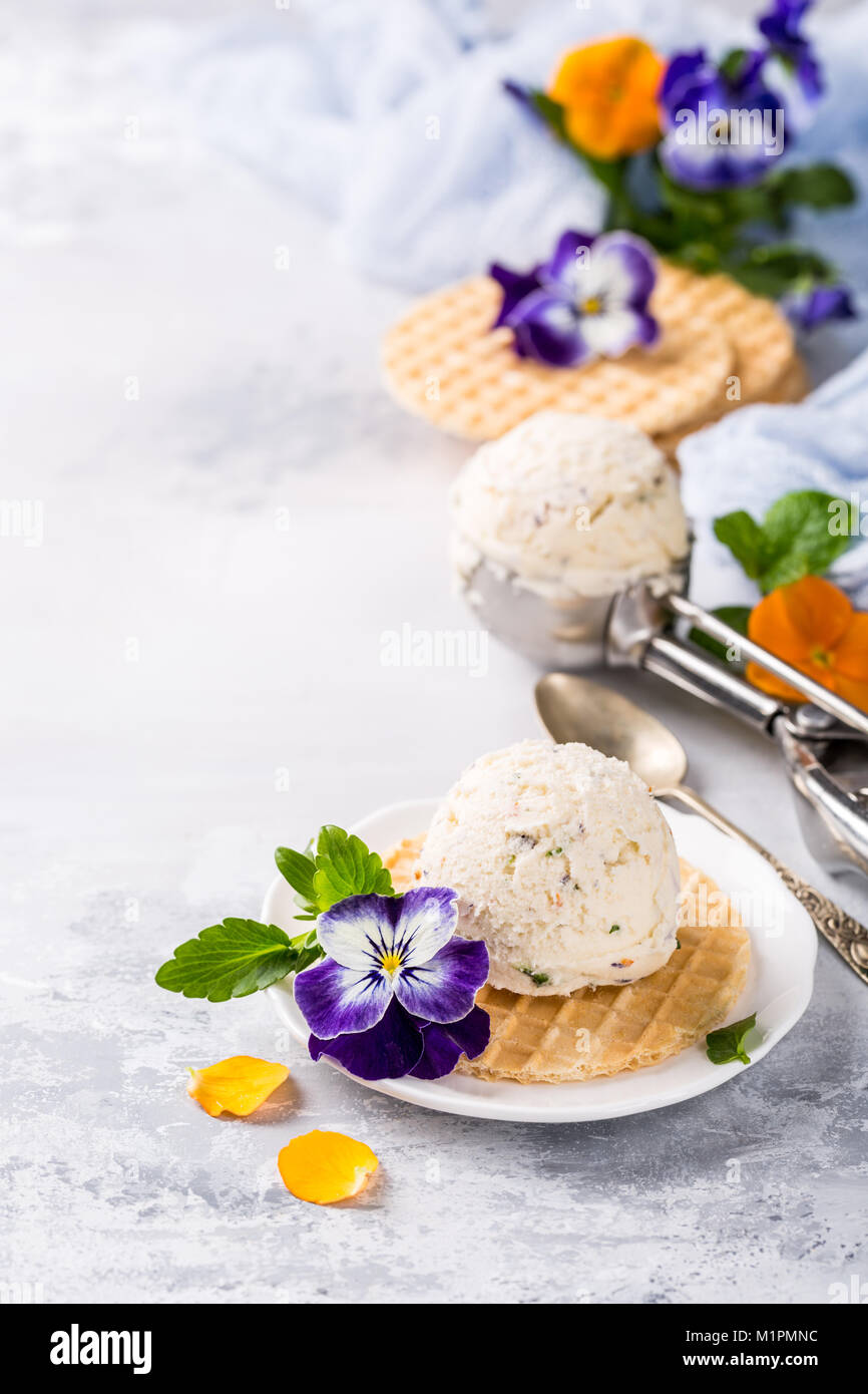 Vanilleeis mit essbaren Blüten Stockfoto