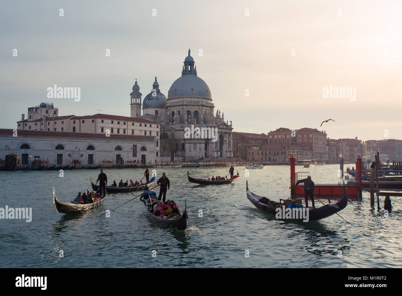 Gondeln in Grand Canal, die Touristen auf Fahrt mit der Basilika von Santa Maria della Salute in der backgroundin Venedig, Italien Stockfoto