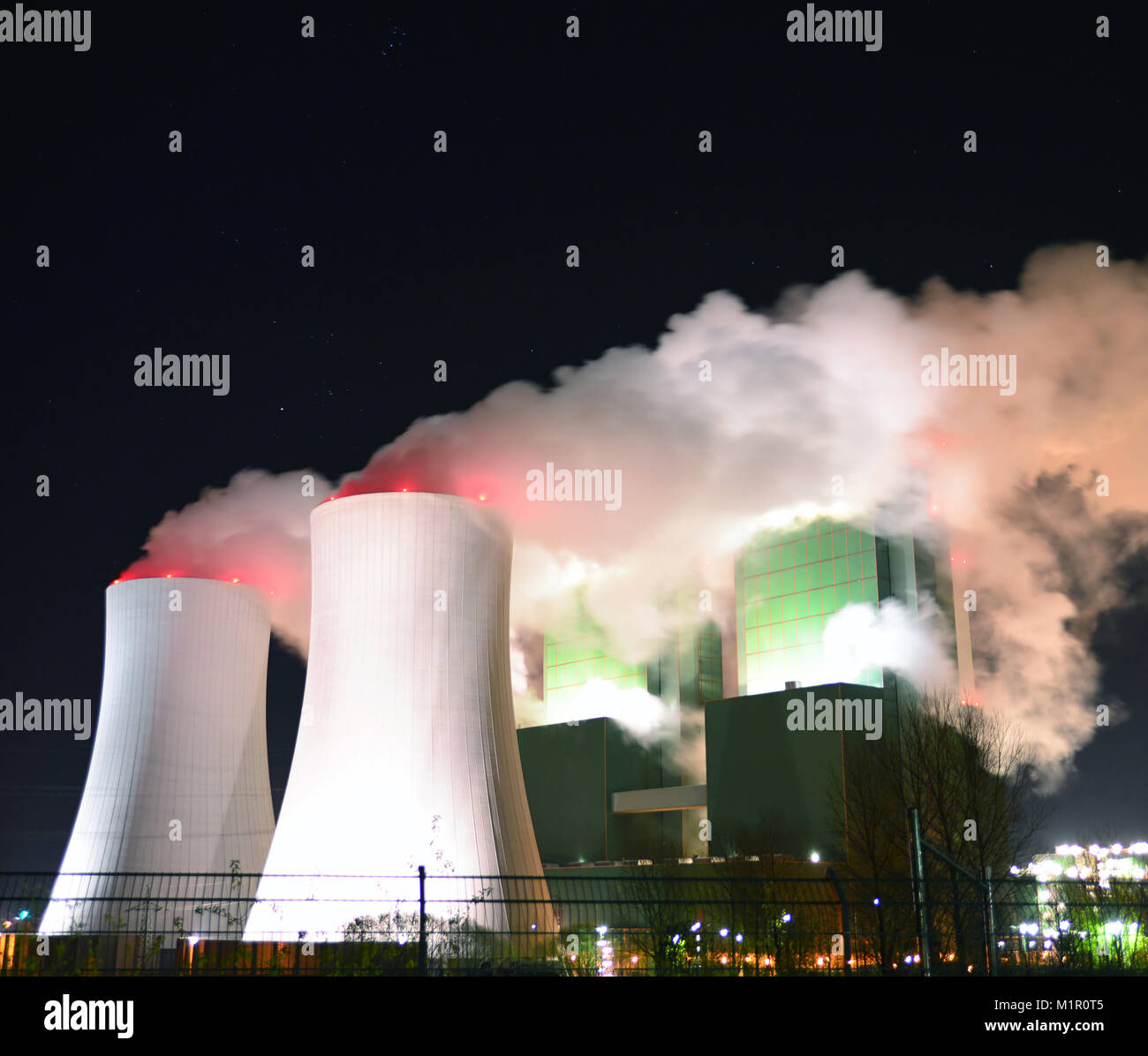 Rauchende Schlote eines Braunkohlekraftwerks in der Nacht Stockfoto
