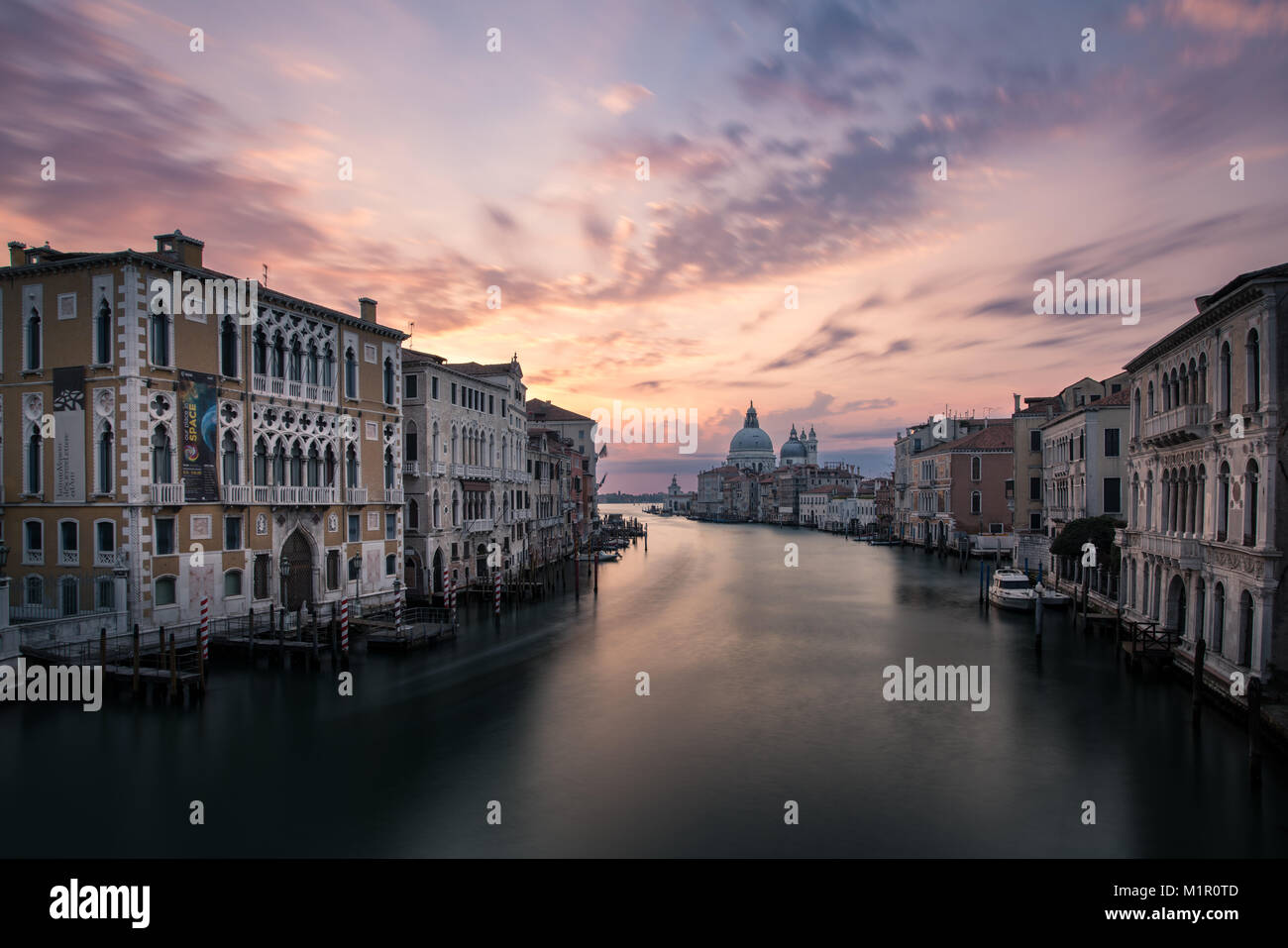 Klassische Ansicht der Canal Grande von der Accademia Brücke mit Basilika di Santa Maria della Salute im Hintergrund bei Sonnenaufgang. Venedig, Italien, 2017 Stockfoto