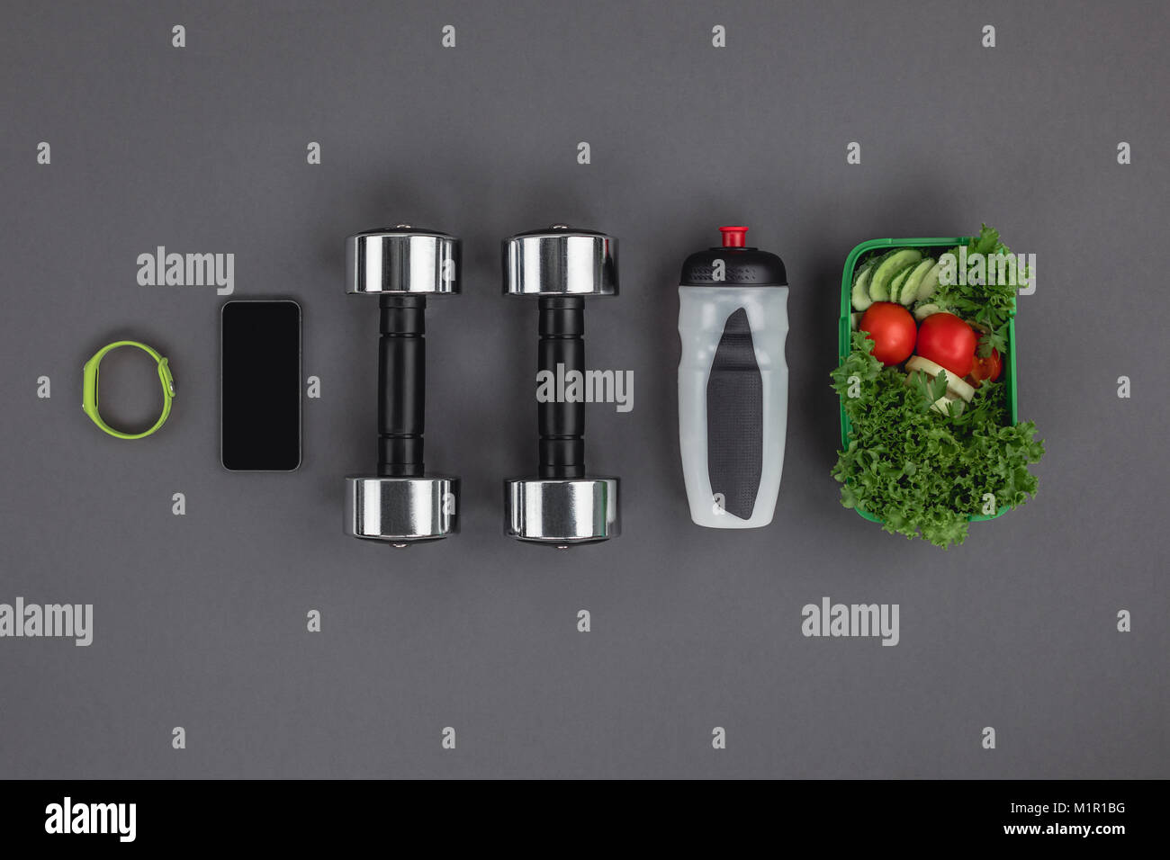 Blick von oben auf die Sport Flasche, Salat und digitale Geräte mit Hanteln Stockfoto