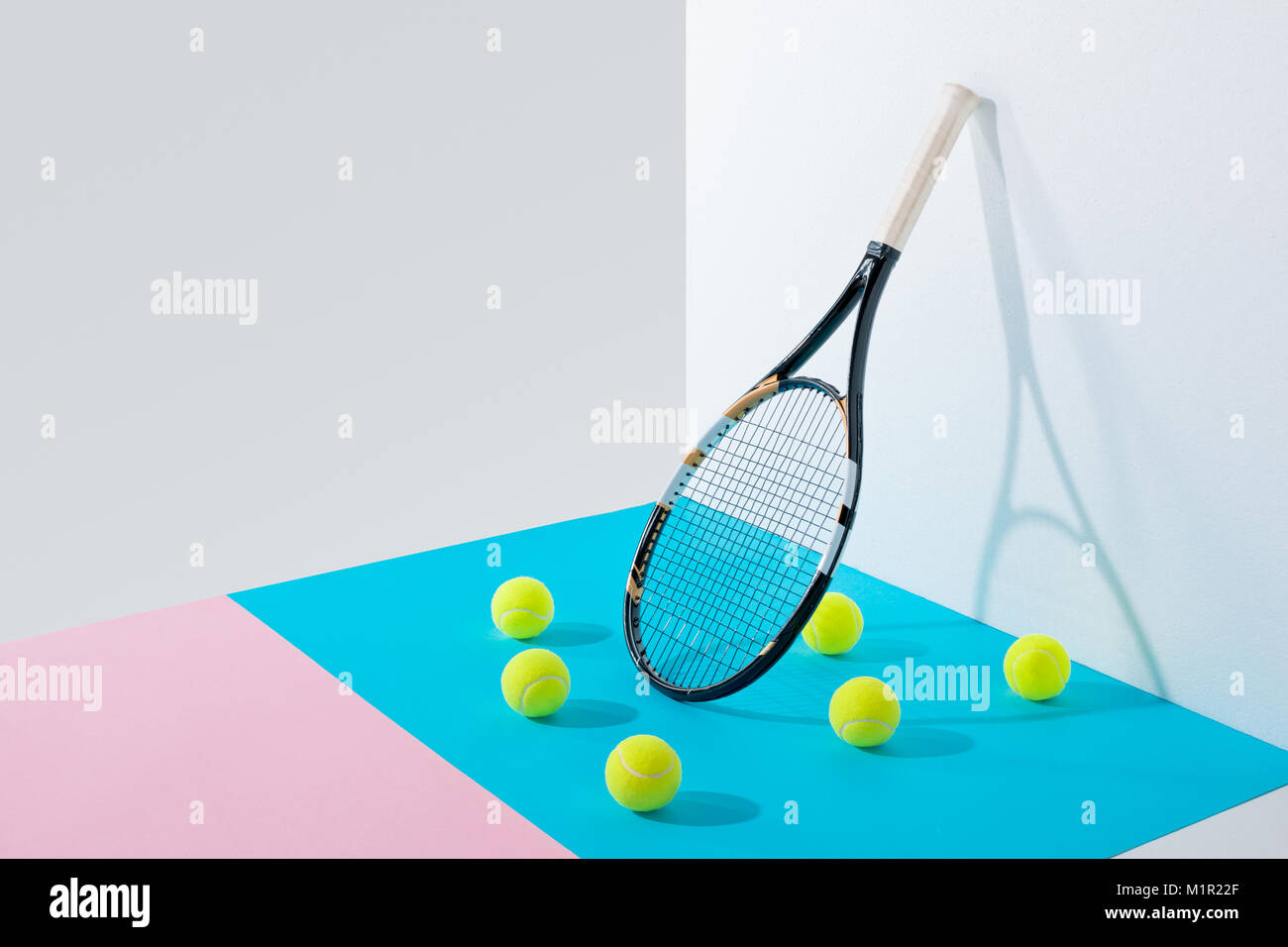 Gelbe Tennisbälle auf Blau und Rosa Papiere Stockfoto