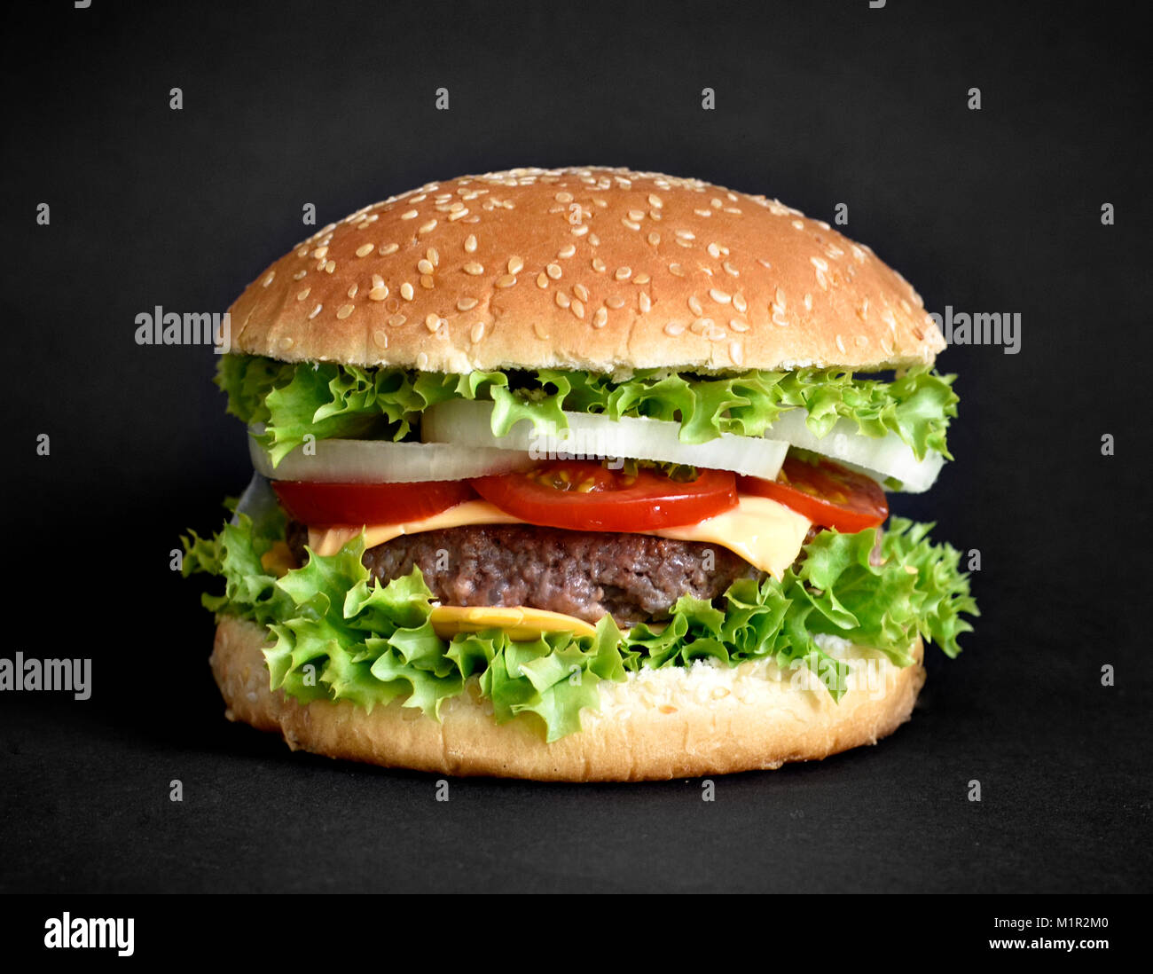Leckere Burger, Hamburger oder Cheeseburger mit Sesam Brötchen und frische Zutaten. Auf schwarzem Hintergrund isoliert. Gourmet Burger mit frischer Salat. Stockfoto