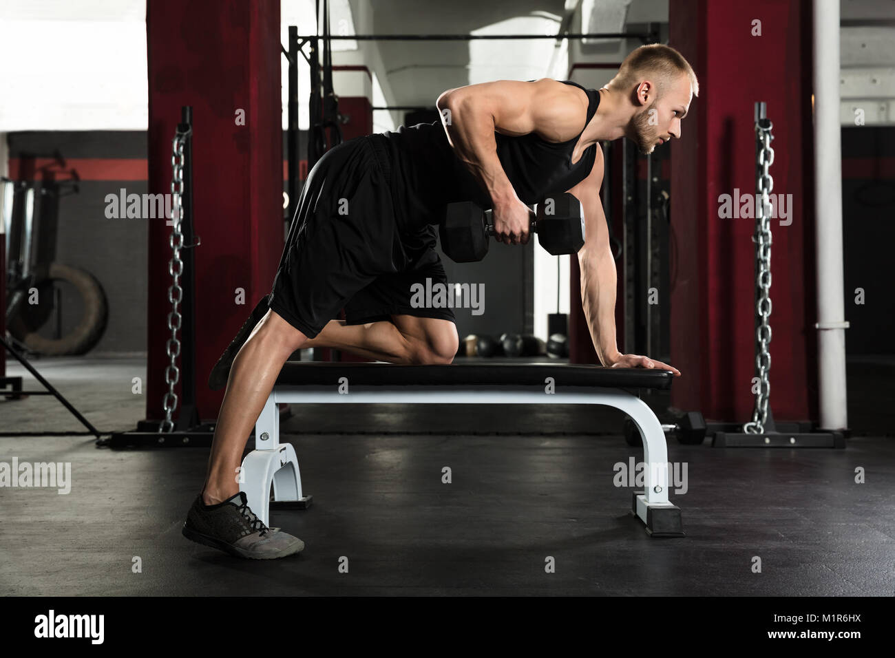 Junger Mann mit Hantel Trainieren im Fitnessstudio Stockfoto