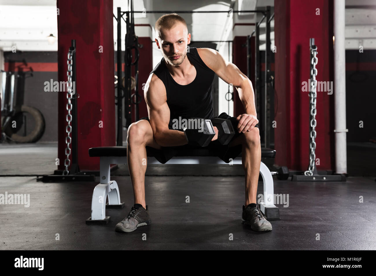 Junger Mann mit Hantel Trainieren im Fitnessstudio Stockfoto