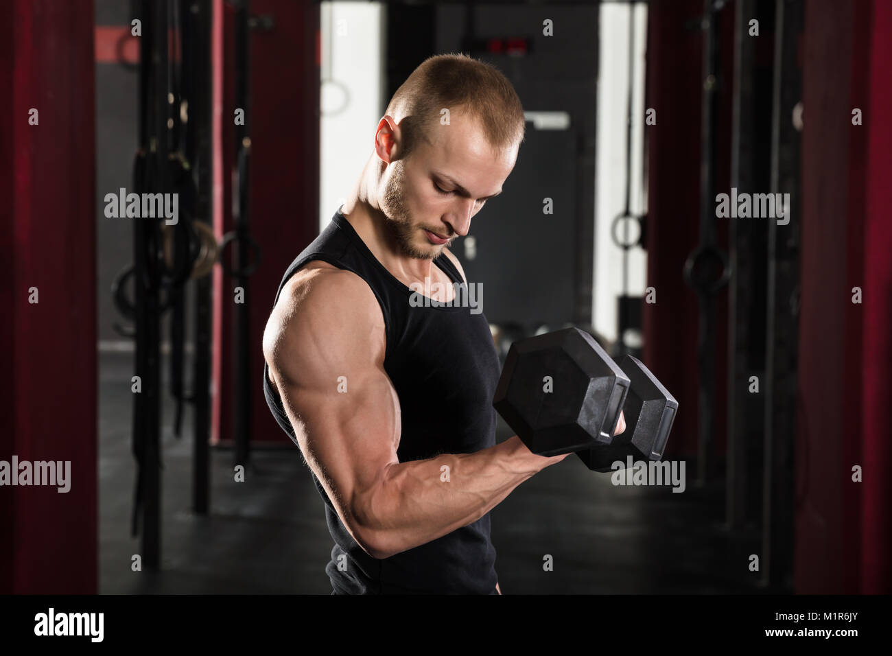 Porträt eines jungen Mannes im Fitnessstudio Hantel Anheben Stockfoto