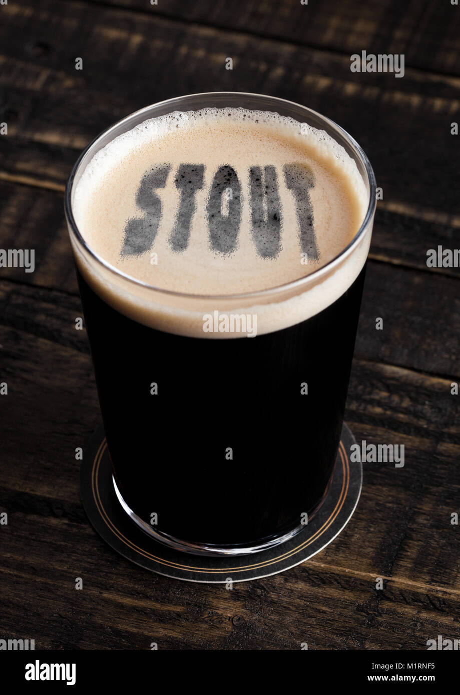 Glas Stout Bier top mit Buchstaben Form auf Holz- Hintergrund Stockfoto