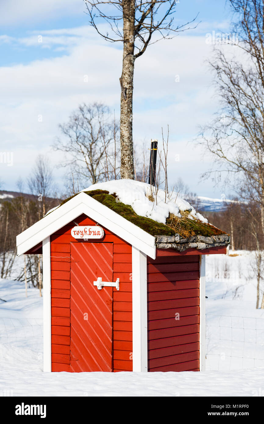Overbygd, Norwegen. Kleine rote Plumpsklo mit natürlichen Dach. Stockfoto