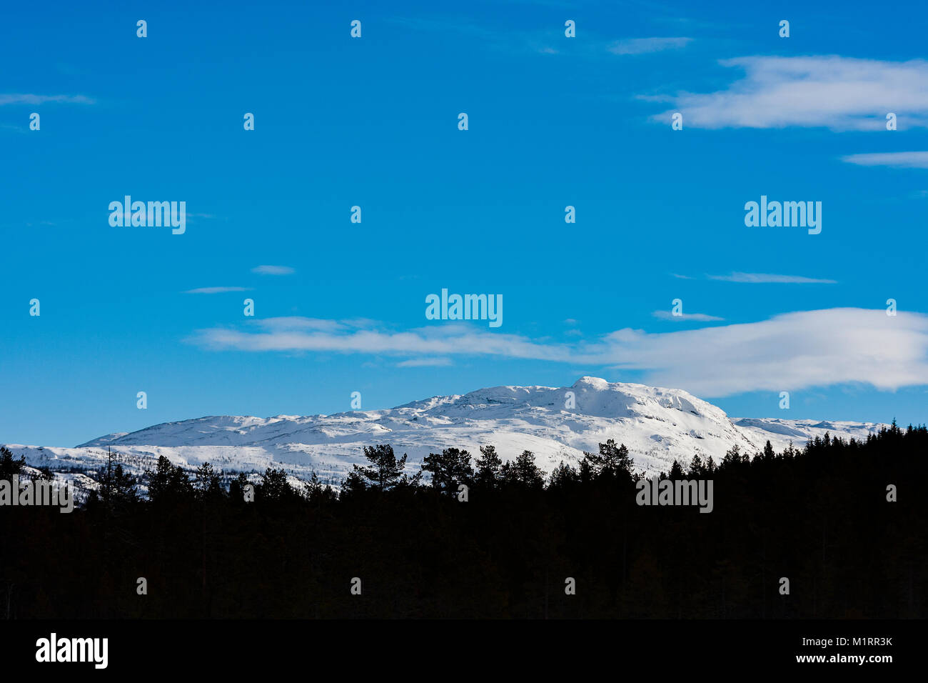 Overbygd, Norwegen. Schneebedeckte Berge unter blauem Himmel. Stockfoto