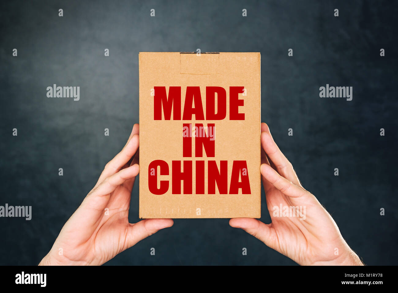 Mann mit Karton Produkt Paket mit Made in China label Impressum für Handelswaren aus Ostasien importiert Stockfoto