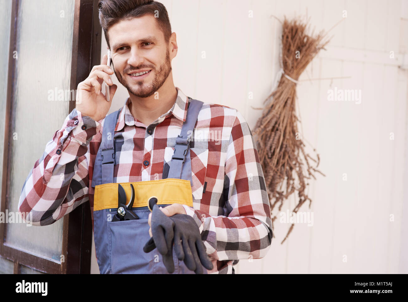 Fröhliche Gärtner Gespräch per Handy Stockfoto