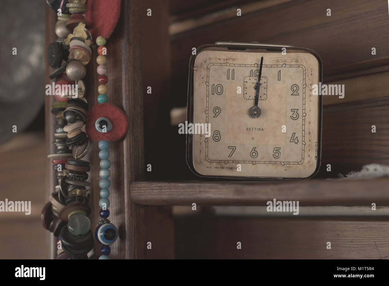 Alte antike Uhr und Perlen auf Holzregal Stockfoto