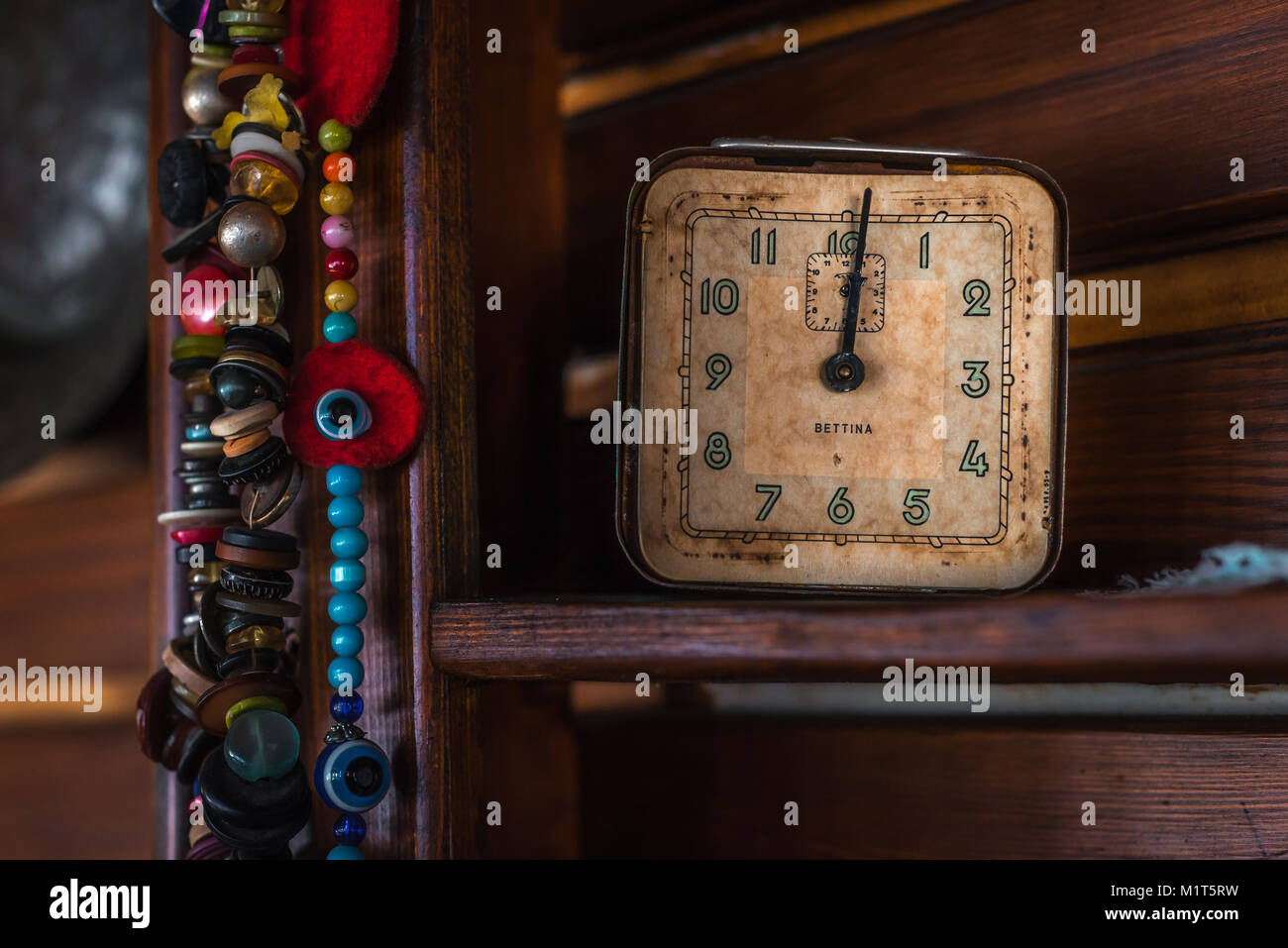 Alte antike Uhr und Perlen auf Holzregal Stockfoto