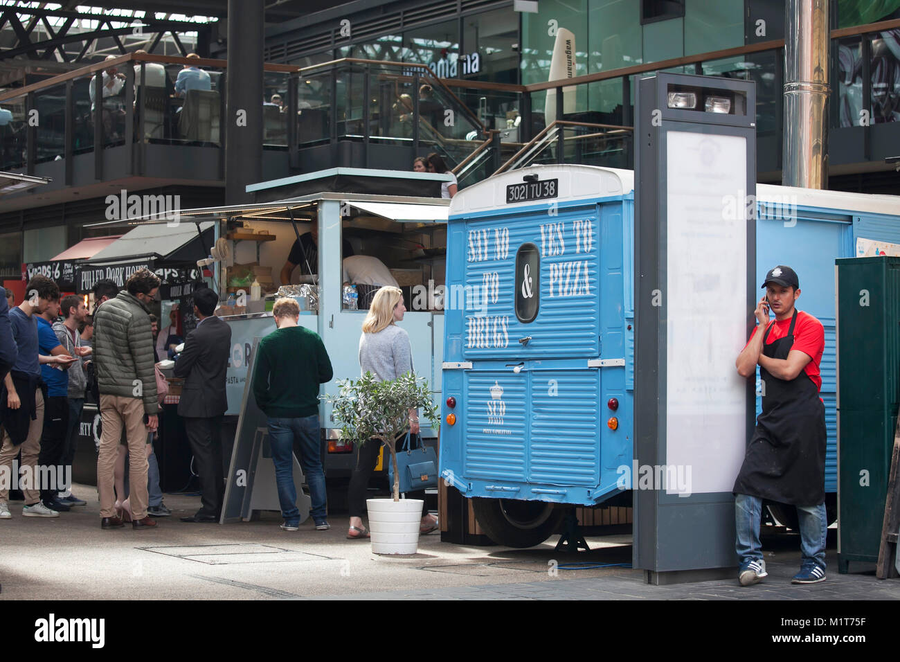 LONDON, ENGLAND - 22. AUGUST 2017 eine Pizza Verkäufer in einem roten T-Shirt und Cap Gespräche am Telefon, stützte sich auf den Van in Spitalfields Market Stockfoto