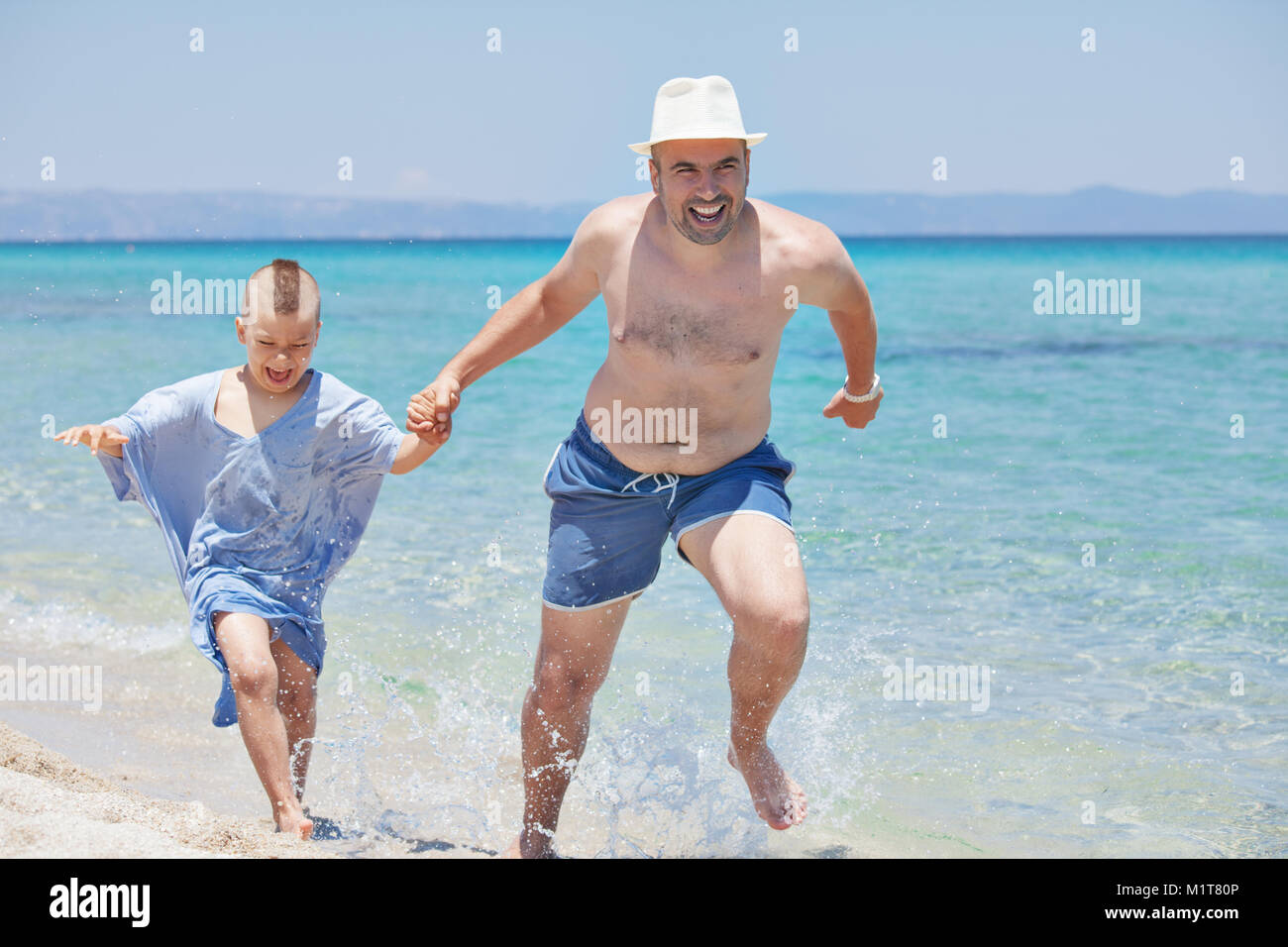 Vater Sohn läuft Seashore Stockfoto