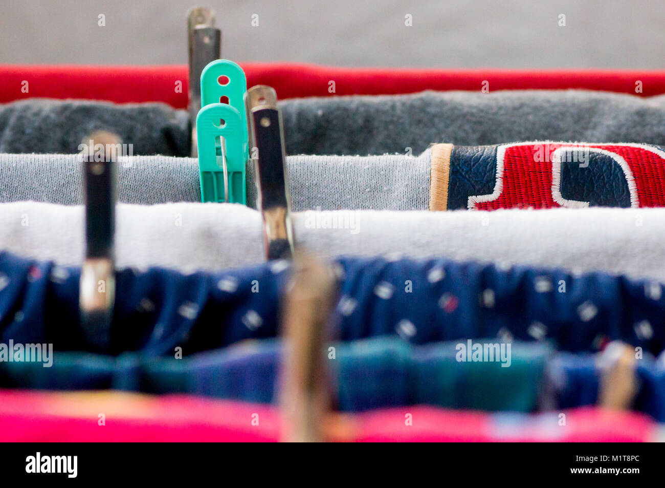 Makroaufnahme der Kleidung trocknen auf einem Kleiderbügel mit Klammern und eine Mischung aus bunten Textilien Stockfoto