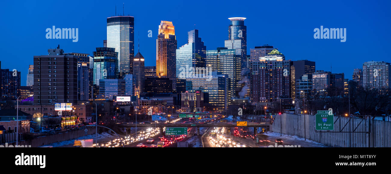 Dämmerung steigt auf Downtown Minneapolis, Minnesota, als aus dem Süden mit der Interstate 35 W im Vordergrund gesehen. Stockfoto