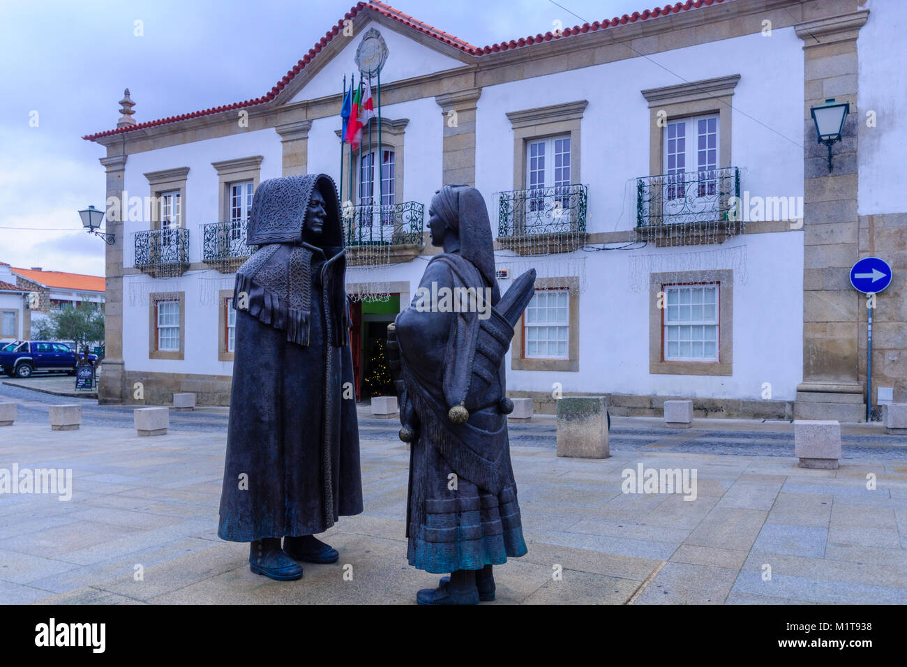 MIRANDA do Douro, PORTUGAL - Dec 25, 2017: Bronze Statuen der Mann, der eine Ehre, Cape und Frau mit traditionellen Winter Kleidung (von Jose Antonio Nobr Stockfoto