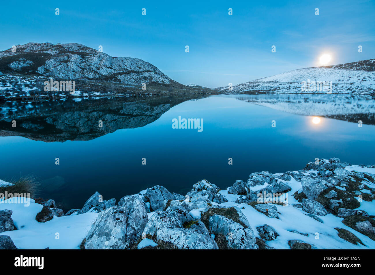 Vollmond in den Seen von Covadonga in Asturien, wo ihre Spiegelungen im Wasser, das Licht, die Farbe, das in einer Winternacht, kontrastiert mit der Schnee Stockfoto