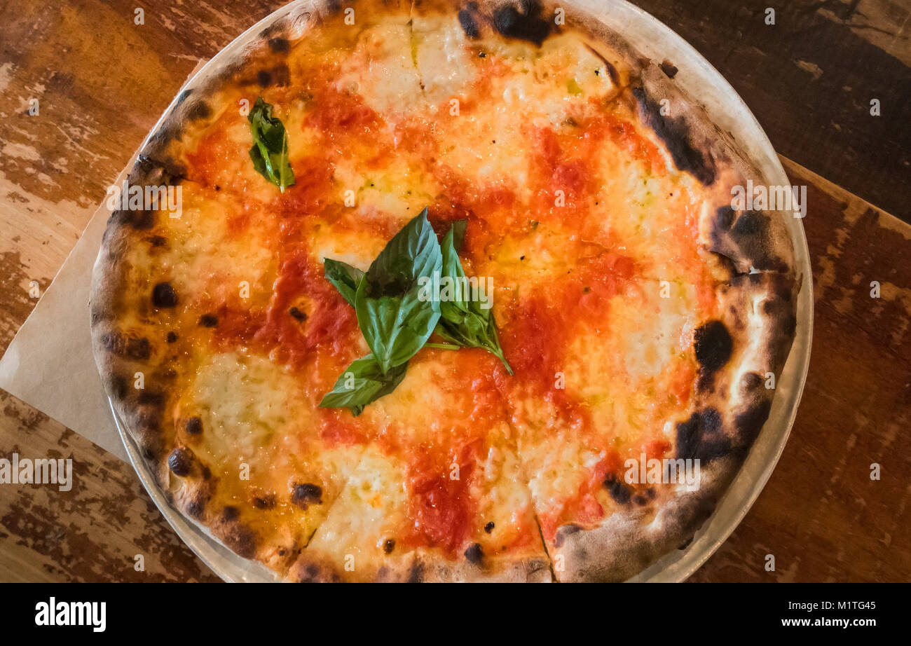 Eine Pizza Margarita mit Mozzarella, Tomaten und Basilikum Stockfoto