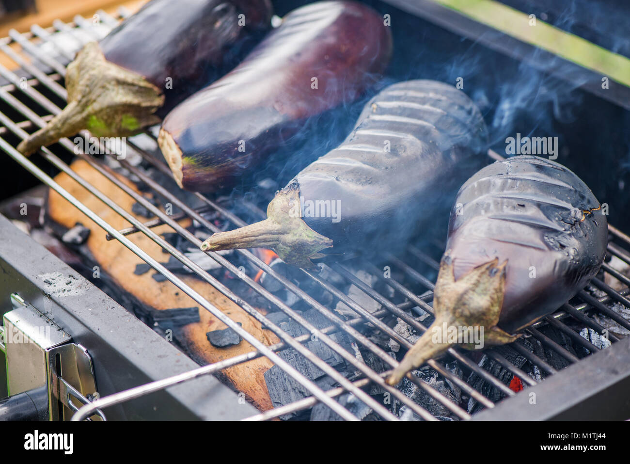 Aubergine auf Grill auf heiße Holzkohle und Feuer. Vorbereitung gesundes  Essen im Urlaub. Kochen Gemüse auf Flammen. Leckeres Essen für Vegetarier  Stockfotografie - Alamy