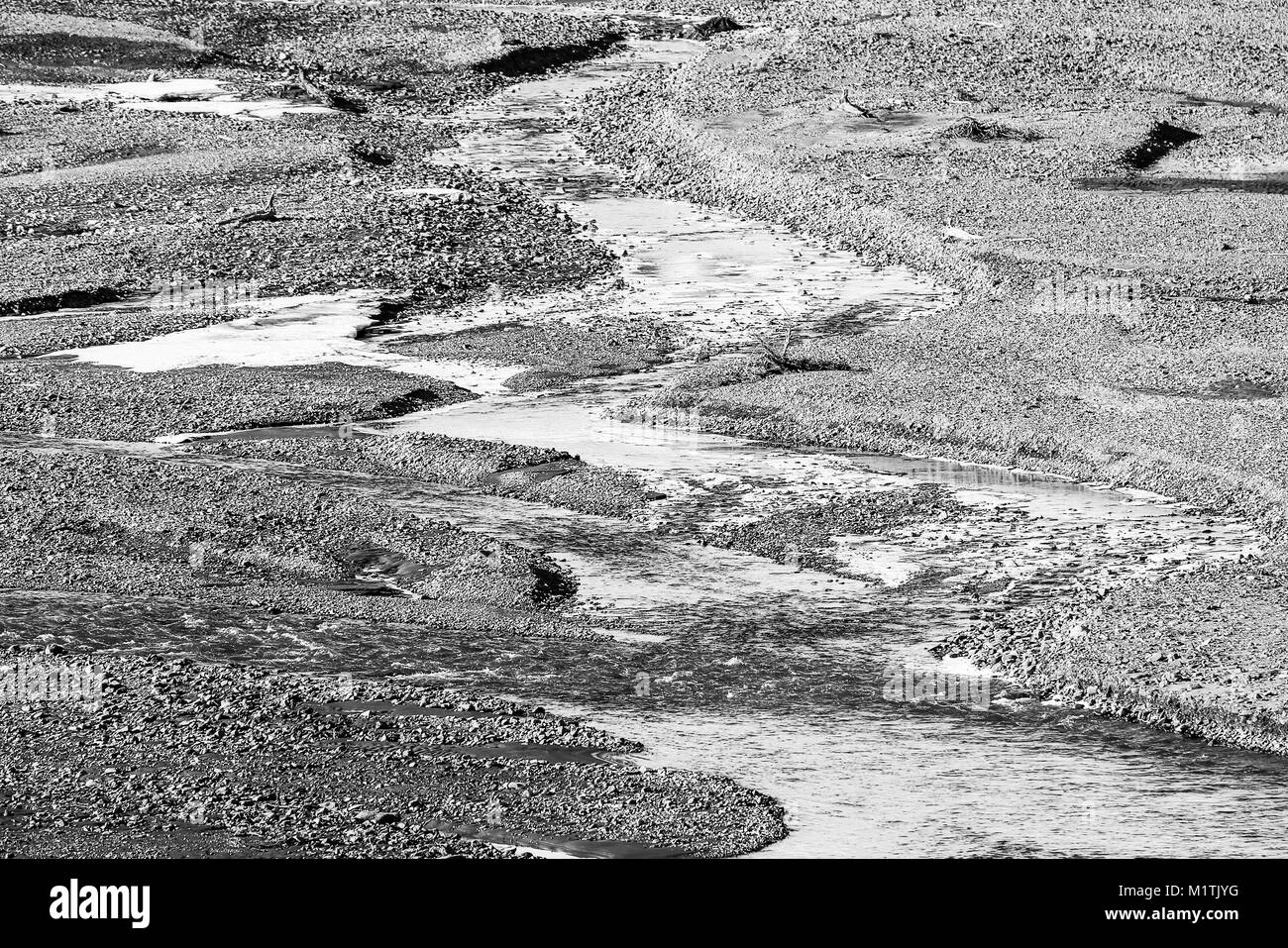 Kleiner Fluss mit grobem Schotter, Schnee und Eis im Denali Nationalpark in Alaska. Stockfoto