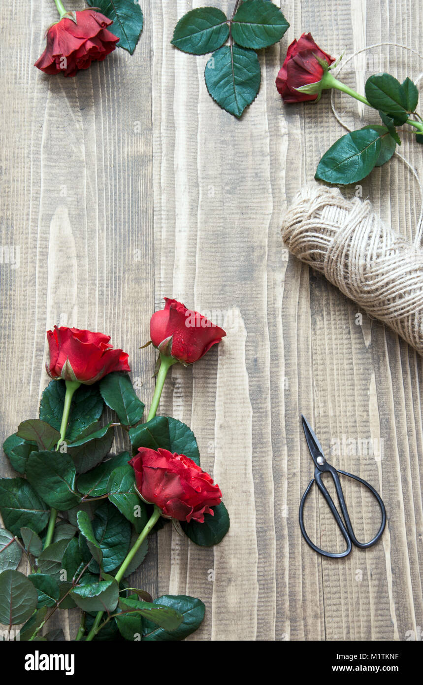 Rote Rosen strauss auf einen hölzernen Tisch. Blick von oben. Im rustikalen Stil. Ansicht von oben. Stockfoto