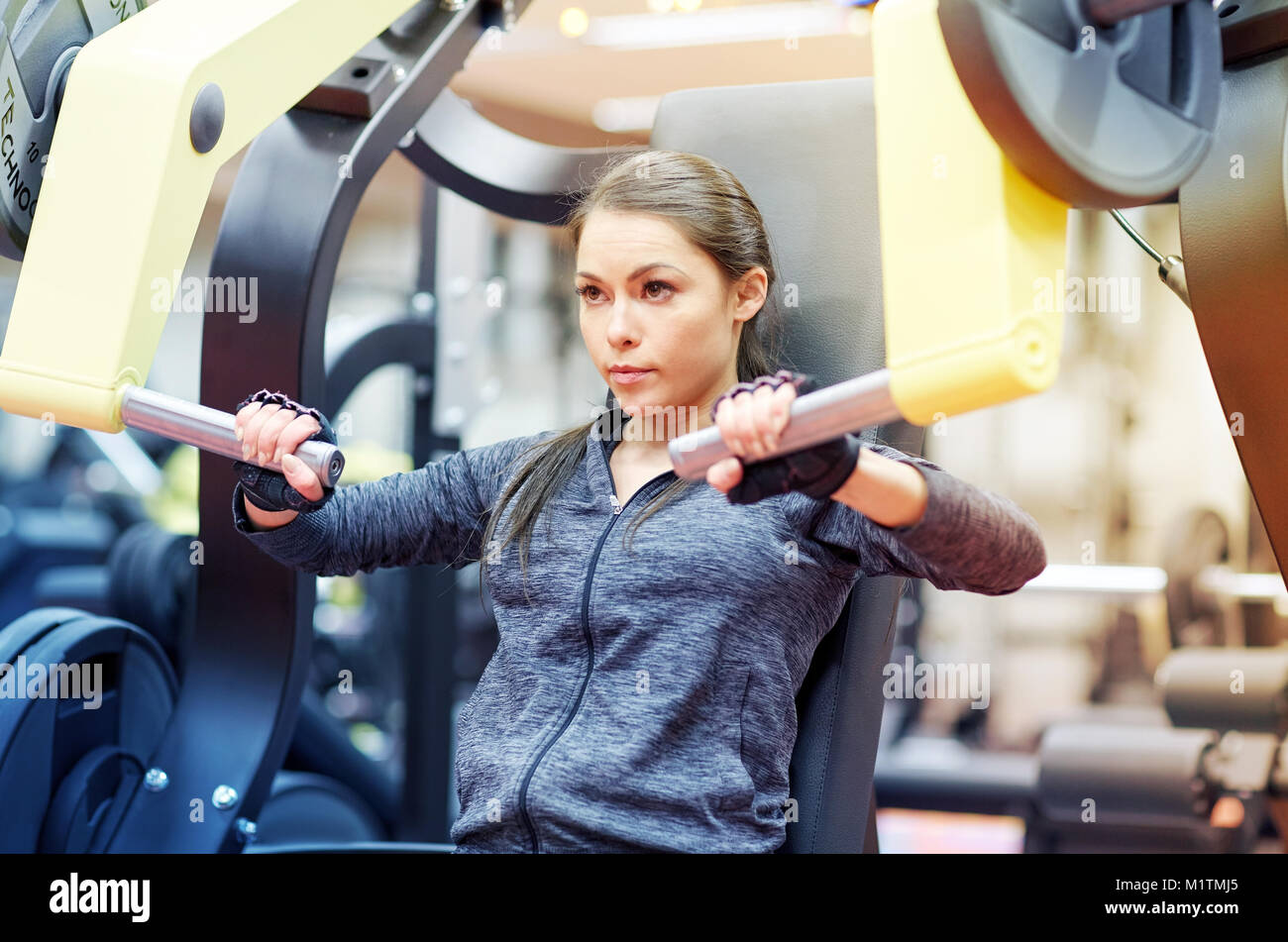 Frau biegen Muskeln an Brust drücken, Fitness-Studio-Maschine Stockfoto