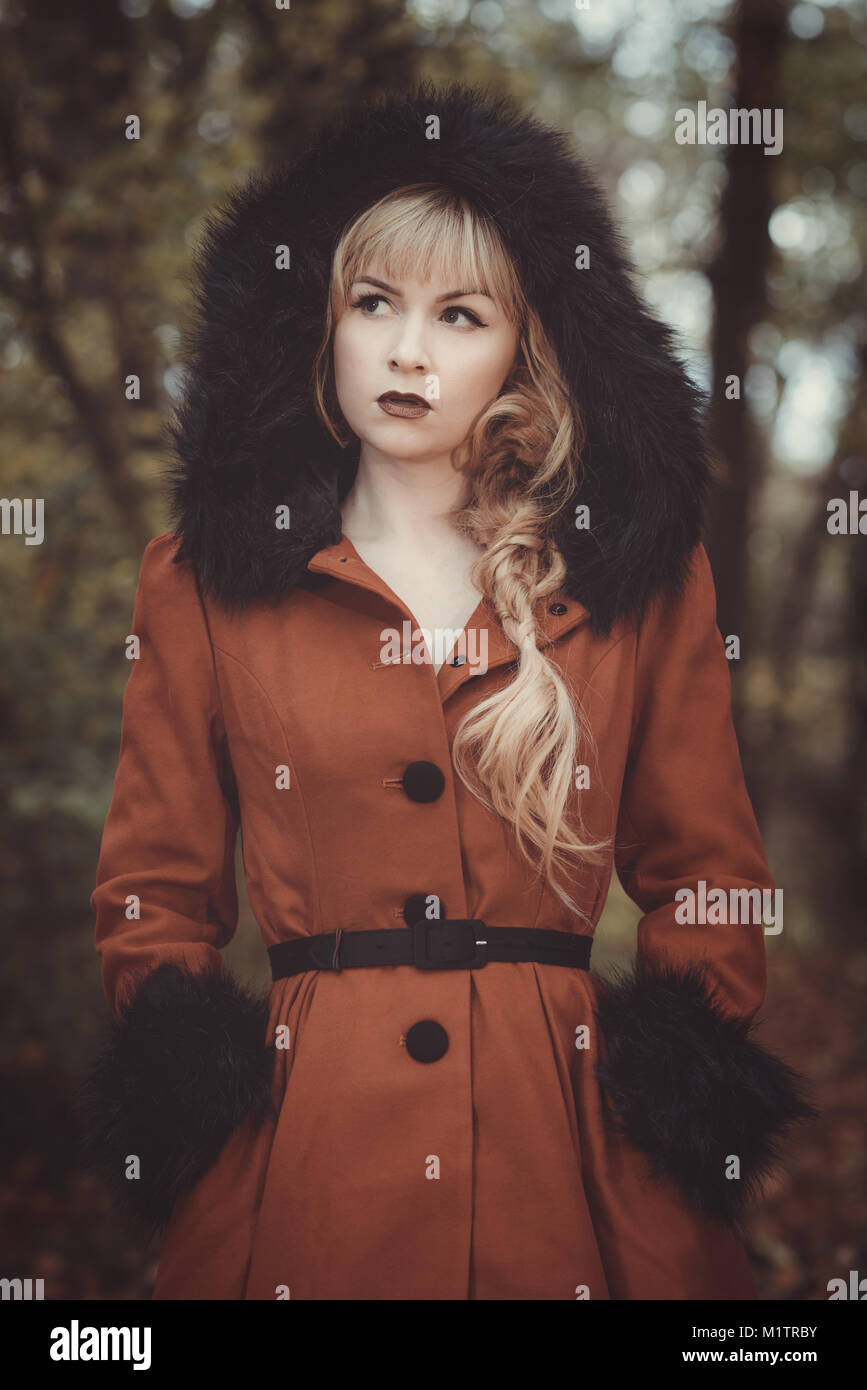 Frau im Vintage Style Mantel mit Kapuze bis im Herbst Wald Stockfoto
