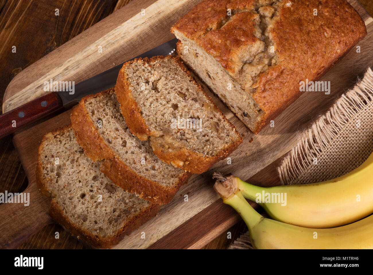 Blick von oben auf die Banane Mutter süßes Brot in Scheiben geschnitten auf einer hölzernen Schneidebrett Stockfoto